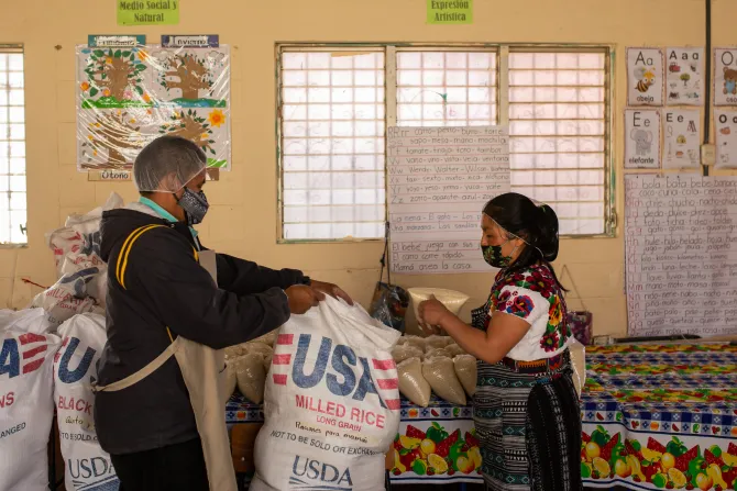 CRS volunteers organize food rations at school
